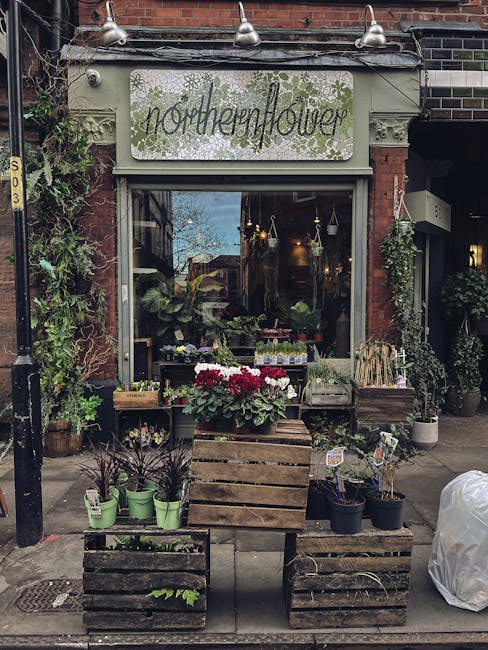 The exterior of Northenflower, a charming floral shop located on a brick building with a large glass display window and a decorative sign reading 'northernflower' above the entrance. In front of the s